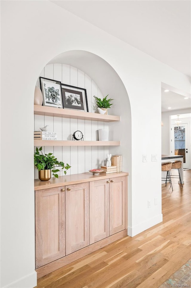 bar with light wood-style flooring and baseboards