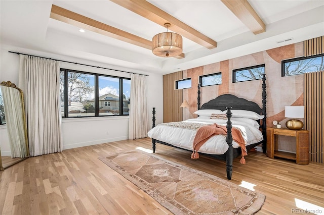 bedroom featuring baseboards, visible vents, wood finished floors, and beamed ceiling