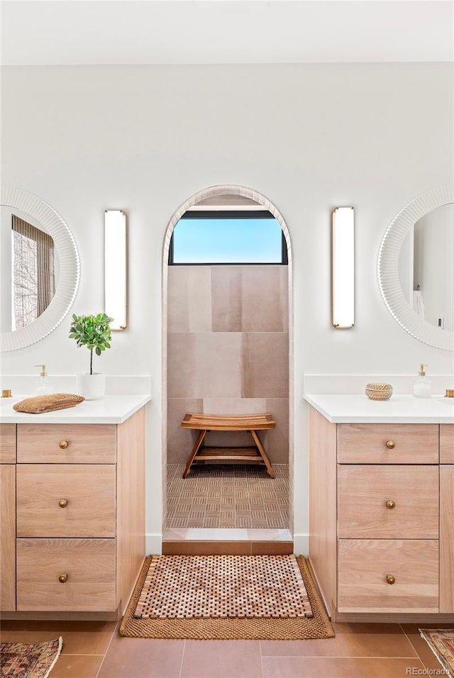 bathroom with tiled shower, vanity, and tile patterned floors