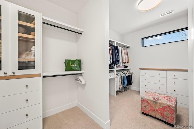 walk in closet with light colored carpet and visible vents