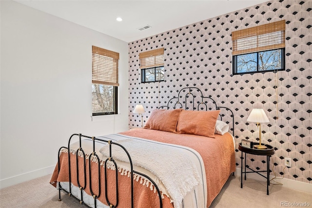 carpeted bedroom with wallpapered walls, visible vents, baseboards, and recessed lighting