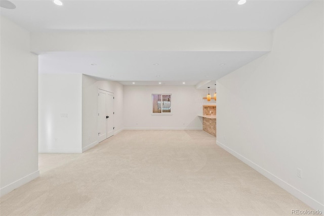 empty room featuring recessed lighting, light carpet, and baseboards