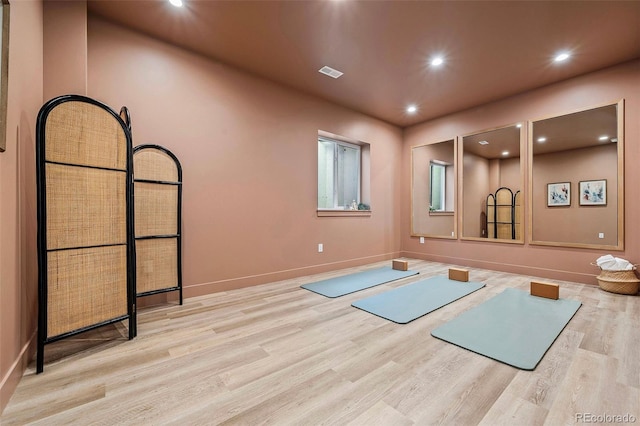 exercise area with recessed lighting, visible vents, baseboards, and wood finished floors