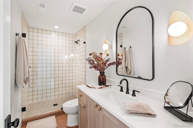 full bath featuring toilet, visible vents, a tile shower, and vanity