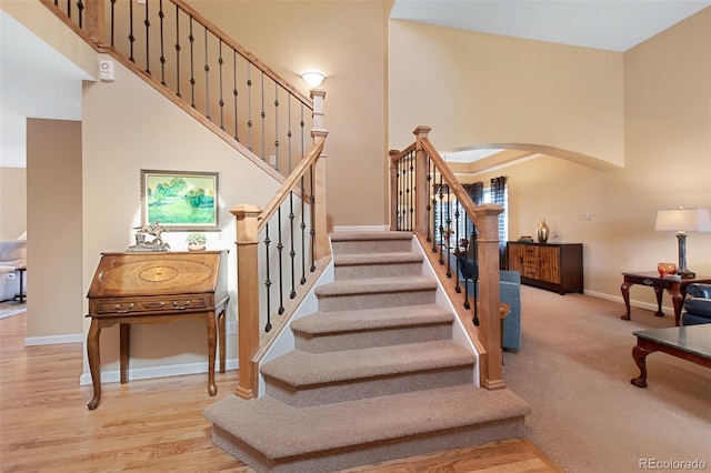 8040 W 78th Cir, Arvada, CO 80005 - staircase featuring arched walkways, baseboards, and a high ceiling