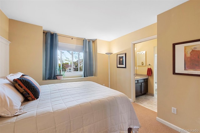 8040 W 78th Cir, Arvada, CO 80005 - bedroom featuring light colored carpet, baseboards, and ensuite bath