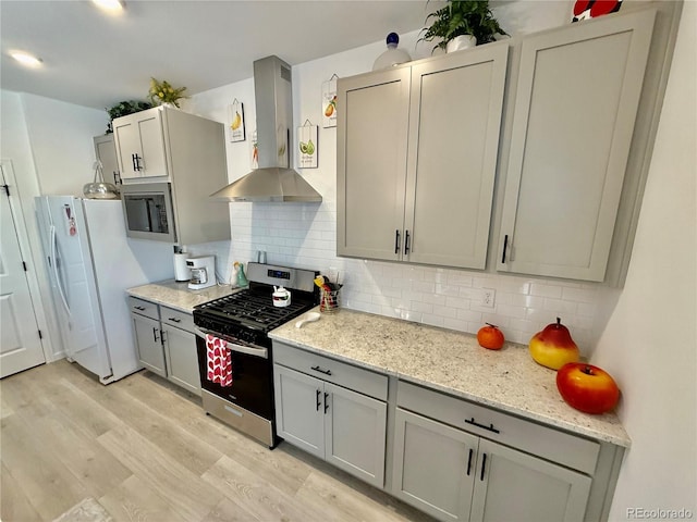 27580 E Cedar Pl, Aurora, CO 80018 - kitchen featuring wall chimney range hood, appliances with stainless steel finishes, light wood finished floors, gray cabinets, and tasteful backsplash