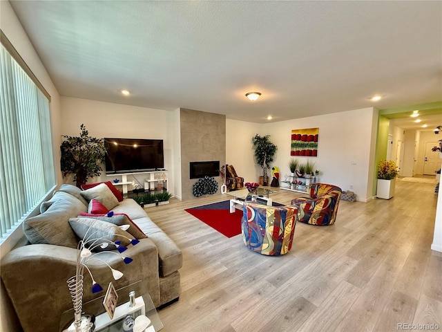 27580 E Cedar Pl, Aurora, CO 80018 - living room featuring light wood finished floors, a tile fireplace, and recessed lighting