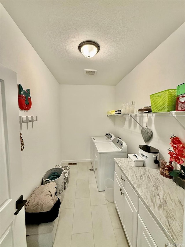 27580 E Cedar Pl, Aurora, CO 80018 - laundry room with washing machine and clothes dryer, a textured ceiling, and light tile patterned floors