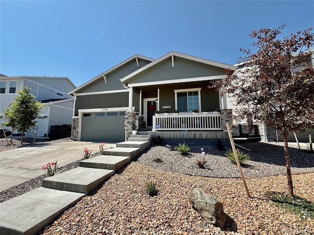 27580 E Cedar Pl, Aurora, CO 80018 - view of front of property with covered porch, an attached garage, concrete driveway, and stone siding