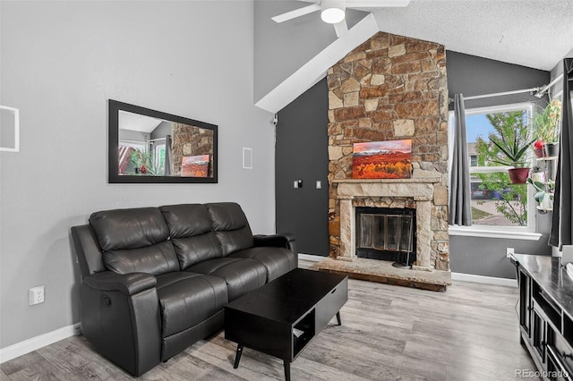 1102 Conifer Ct, Highlands Ranch, CO 80126 - living room featuring a ceiling fan, wood finished floors, a stone fireplace, and high vaulted ceiling