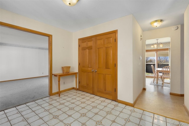 foyer with a notable chandelier and light colored carpet