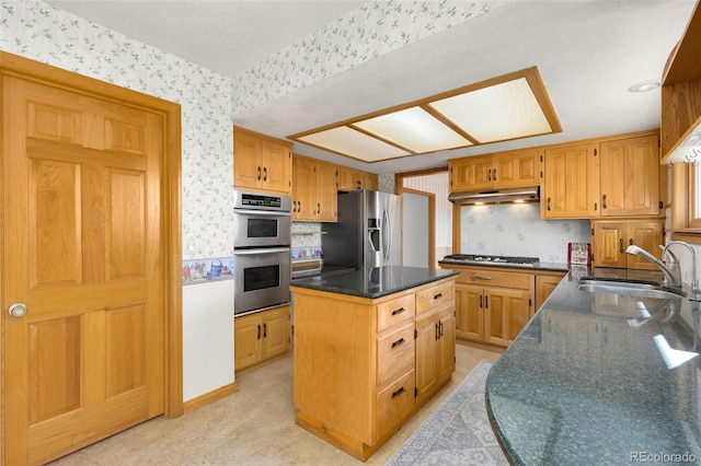 kitchen featuring a center island, light carpet, sink, dark stone countertops, and appliances with stainless steel finishes