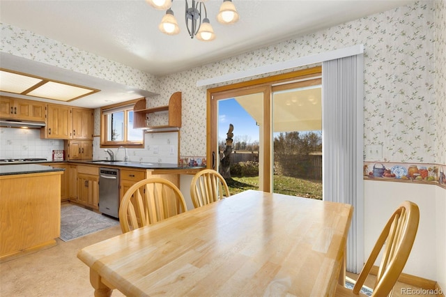 carpeted dining room with sink and a chandelier