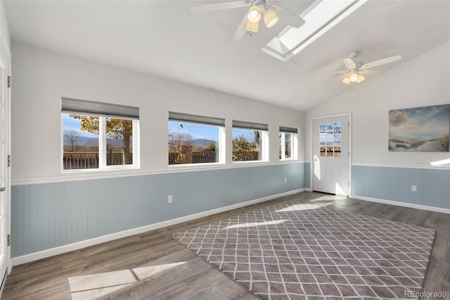 interior space with vaulted ceiling with skylight, wood-type flooring, and a wealth of natural light