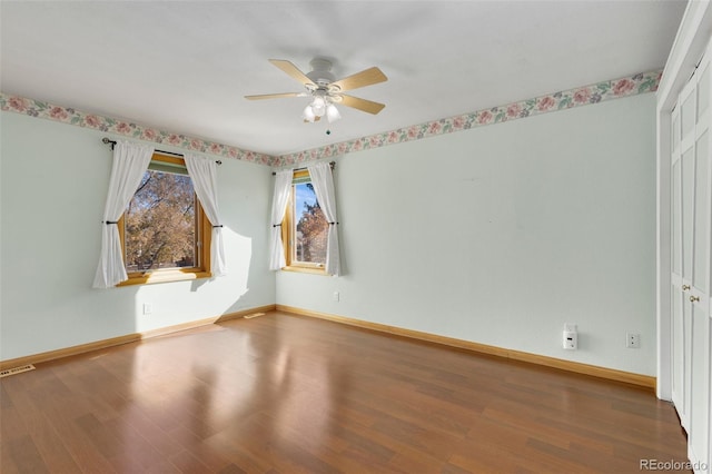 empty room with hardwood / wood-style floors and ceiling fan