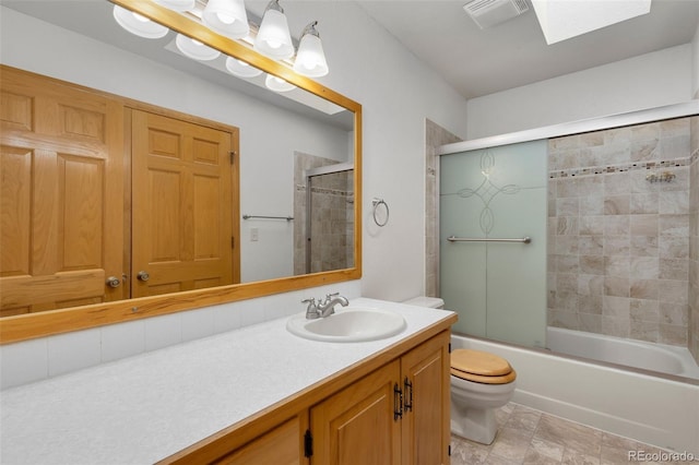 full bathroom featuring shower / bath combination with glass door, vanity, a skylight, and toilet