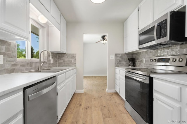 1304 S Lemay Ave, Fort Collins, CO 80524 - kitchen featuring stainless steel appliances, a ceiling fan, white cabinets, decorative backsplash, and light countertops