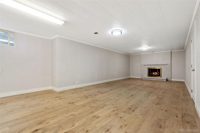 1304 S Lemay Ave, Fort Collins, CO 80524 - unfurnished living room featuring ornamental molding, light wood-type flooring, and a brick fireplace