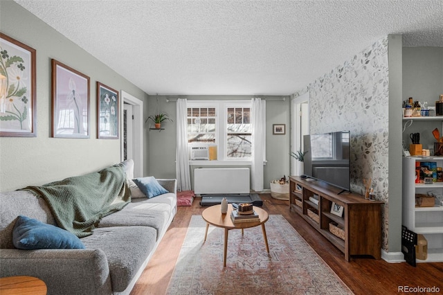 living room featuring radiator, a textured ceiling, and wood finished floors