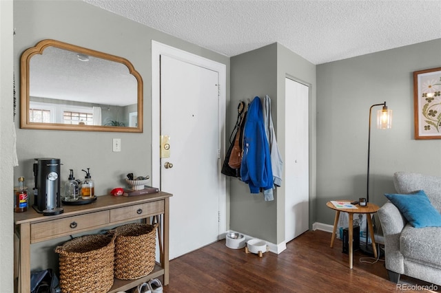 entryway featuring baseboards, a textured ceiling, and dark wood finished floors