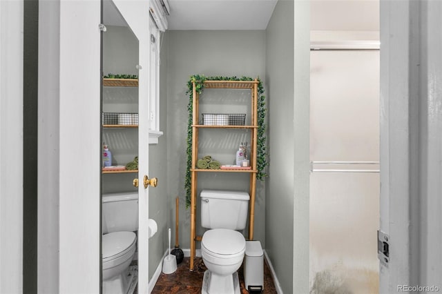 bathroom featuring toilet and baseboards