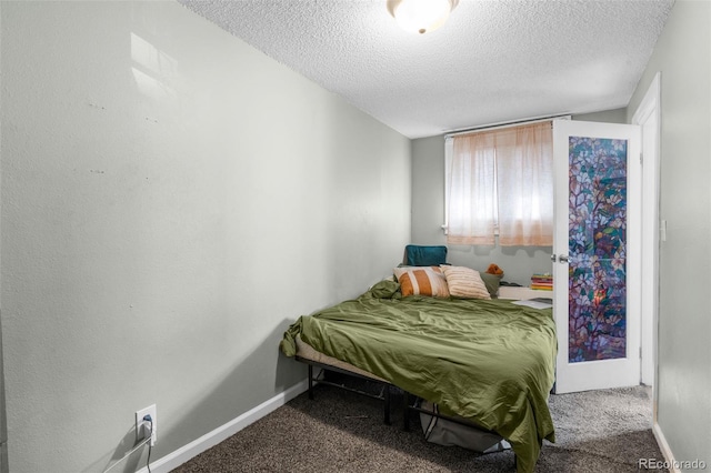 carpeted bedroom with baseboards and a textured ceiling