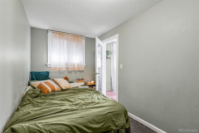 carpeted bedroom with baseboards and a textured ceiling