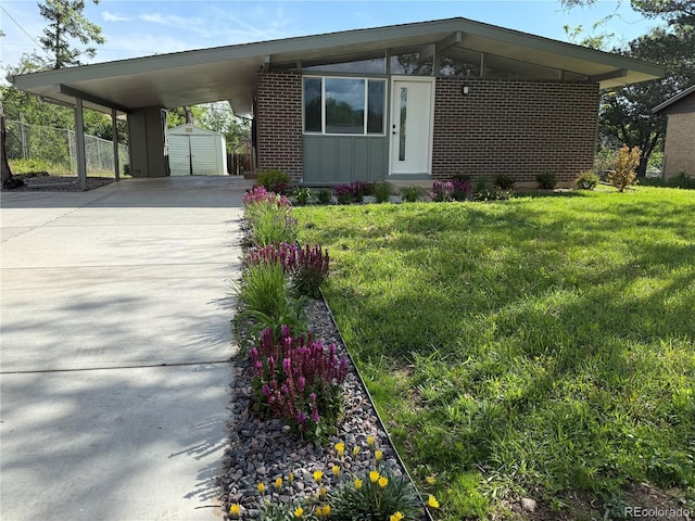 3355 Moorhead Ave, Boulder, CO 80305 - view of front of house featuring driveway, a front yard, brick siding, an outbuilding, and an attached carport