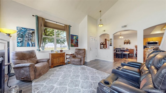 10449 Paris St Unit 207, Commerce City, CO 80640 - living room with arched walkways, wood finished floors, high vaulted ceiling, and a chandelier