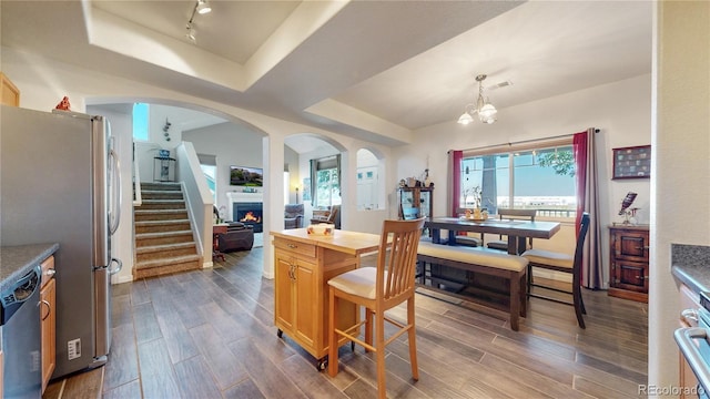10449 Paris St Unit 207, Commerce City, CO 80640 - kitchen featuring stainless steel appliances, arched walkways, dark wood-style floors, and healthy amount of natural light