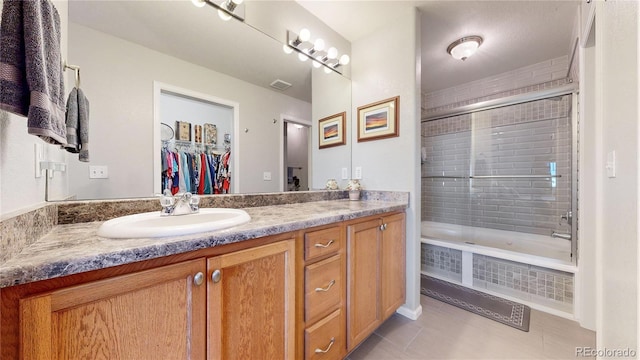 10449 Paris St Unit 207, Commerce City, CO 80640 - bathroom with tile patterned flooring, vanity, tiled shower / bath, and a walk in closet