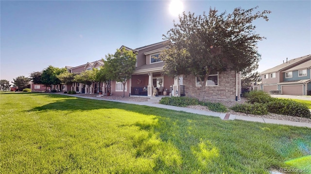10449 Paris St Unit 207, Commerce City, CO 80640 - view of property hidden behind natural elements with a porch, a front yard, and stone siding