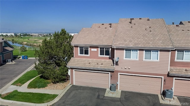 10449 Paris St Unit 207, Commerce City, CO 80640 - back of property with an attached garage, driveway, and a water view