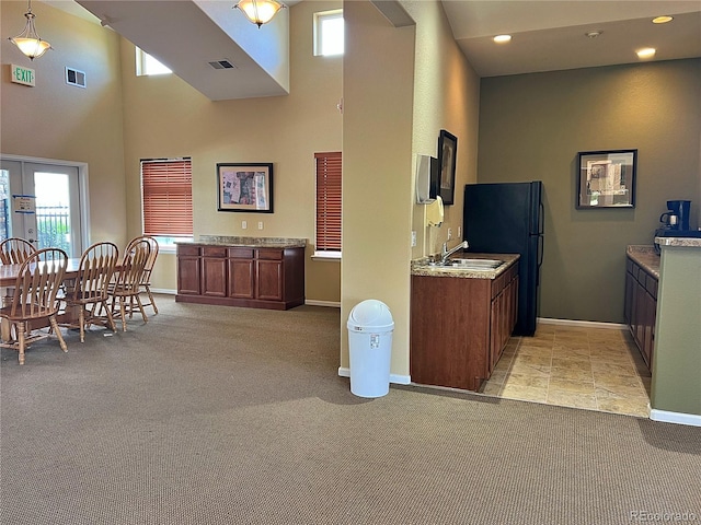 10449 Paris St Unit 207, Commerce City, CO 80640 - kitchen with a towering ceiling, light carpet, plenty of natural light, freestanding refrigerator, and french doors