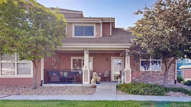 10449 Paris St Unit 207, Commerce City, CO 80640 - view of front of house featuring covered porch and stone siding