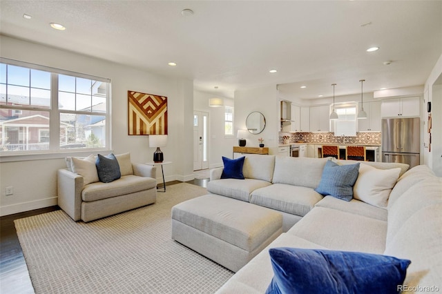 living room with recessed lighting, baseboards, and wood finished floors
