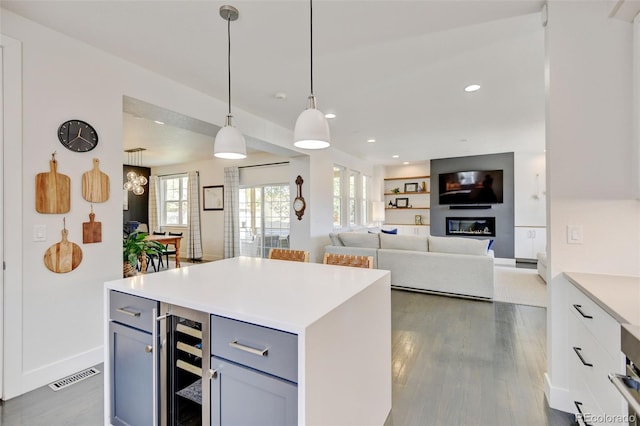 kitchen featuring visible vents, light countertops, dark wood finished floors, wine cooler, and gray cabinetry