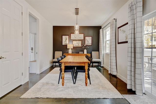 dining space with baseboards, plenty of natural light, and dark wood-type flooring