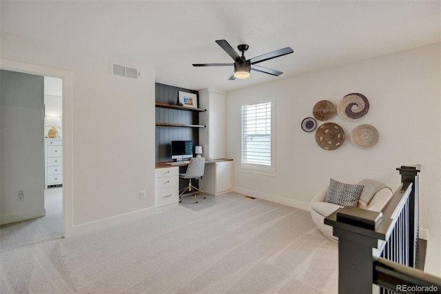 home office with ceiling fan, visible vents, built in study area, baseboards, and carpet flooring