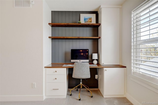 home office featuring baseboards, carpet, built in desk, and visible vents