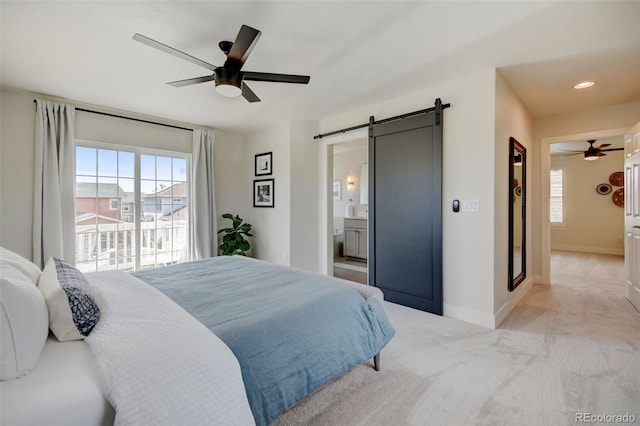 bedroom with baseboards, multiple windows, a barn door, and light colored carpet