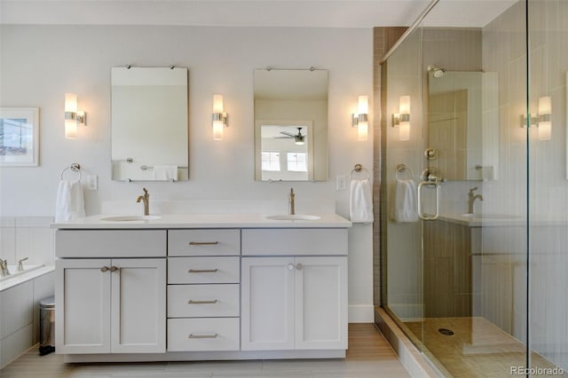 bathroom featuring a sink, ceiling fan, and a shower stall
