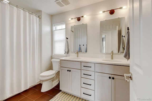bathroom with a sink, tile patterned flooring, toilet, and double vanity
