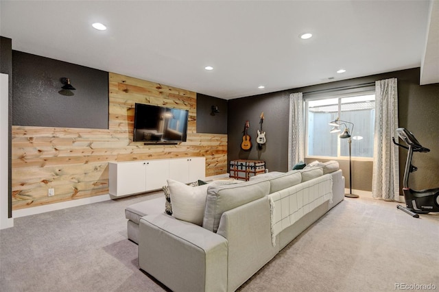 living area with baseboards, wooden walls, an accent wall, light carpet, and recessed lighting
