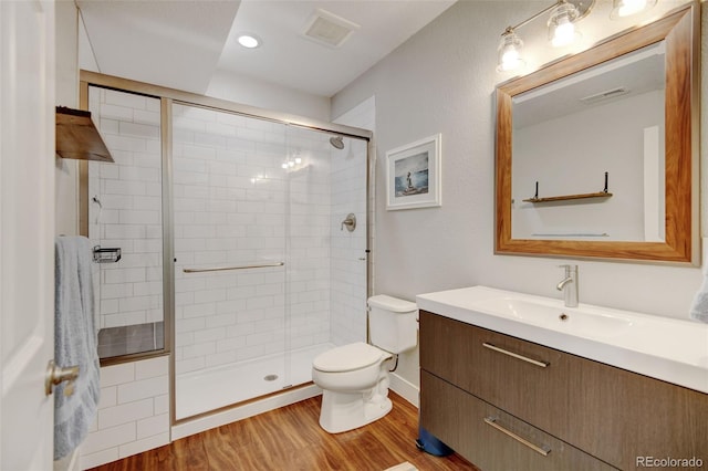 bathroom featuring visible vents, a stall shower, toilet, and wood finished floors