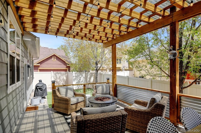 deck with a fenced backyard, a pergola, and a fire pit