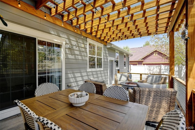 wooden deck with fence, outdoor dining space, a pergola, and an outdoor fire pit