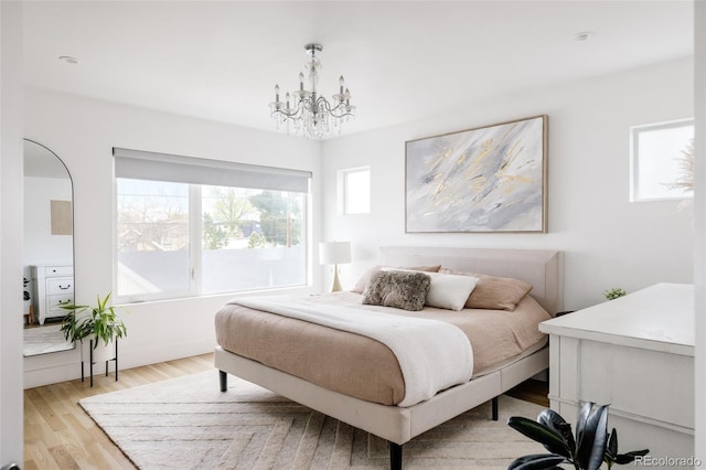 bedroom with a chandelier and light hardwood / wood-style floors