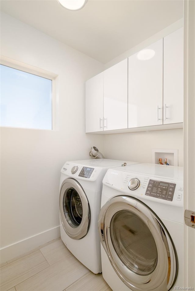 laundry room featuring washing machine and dryer and cabinets